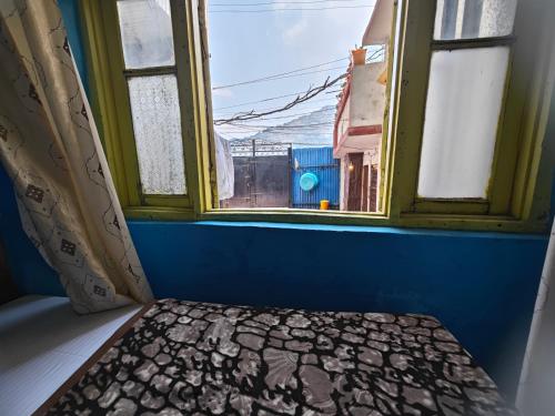 a window in a room with a bench in front at Lake Boulevard Guest House in Srinagar