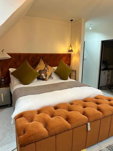 a bedroom with a large bed with a brown tufted headboard at Maison Norelle at Isivuno House in Gillitts