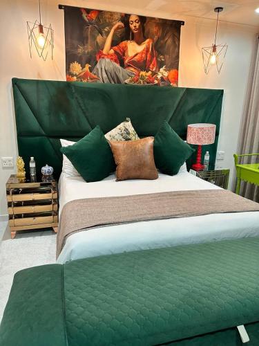 a bedroom with a green bed with a painting on the wall at Maison Norelle at Isivuno House in Gillitts
