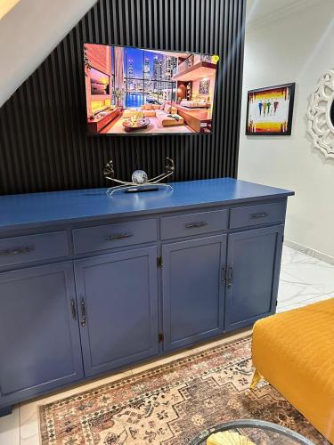 a blue cabinet with a tv on top of it at Maison Norelle at Isivuno House in Gillitts
