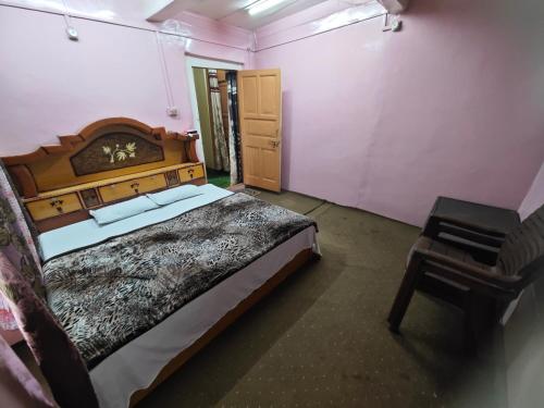 a bedroom with a large bed and a chair at Lake Boulevard Guest House in Srinagar