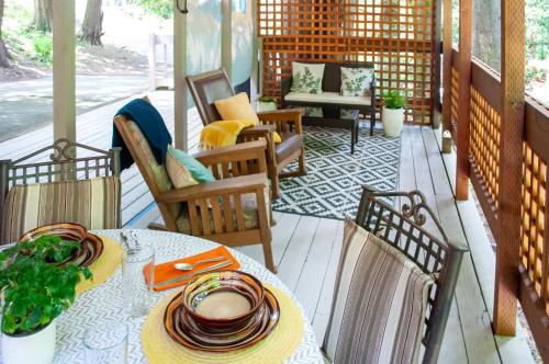 a patio with a table and chairs on a porch at The Owls Nest with Hot Tub and Forest Views! in Portland