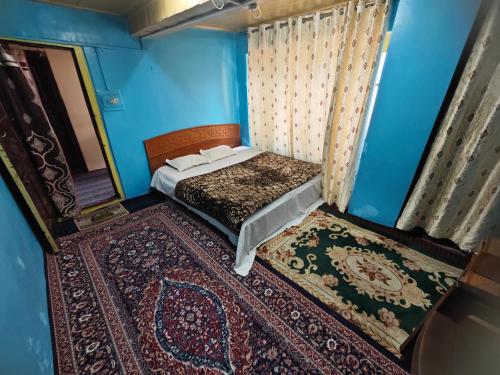 a bedroom with a bed in a blue room at Lake Boulevard Guest House in Srinagar
