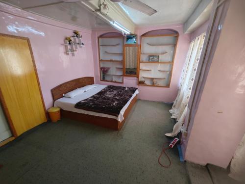 a bedroom with a bed in a pink room at Lake Boulevard Guest House in Srinagar