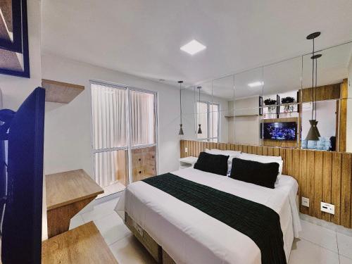 a bedroom with a large bed and a large window at Walk Bueno, Próximo Parque Vaca Brava e Goiânia Shopping. in Goiânia
