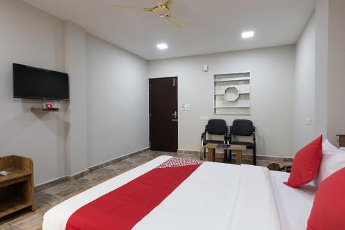 a bedroom with a bed and a flat screen tv at Hotel O Nestle inn in Chennai