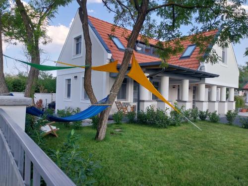a kite hanging from a tree in front of a house at Papoula Vendégház - Köveskál in Köveskál
