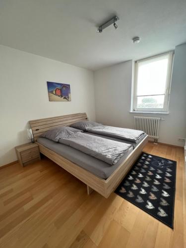 a bedroom with a large bed and a wooden floor at Tobi‘s Ferienapartment in Gottmadingen