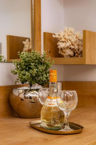 a bottle of alcohol and two wine glasses on a table at My Savvas Studios in Haraki
