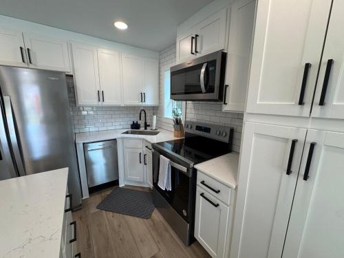 a kitchen with white cabinets and a stainless steel refrigerator at Modern 3BR, 2BAHome Near Georgetown Square Sleeps 6 in Georgetown