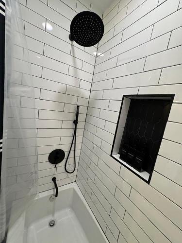 a white tiled bathroom with a tub and a window at Modern 3BR, 2BAHome Near Georgetown Square Sleeps 6 in Georgetown