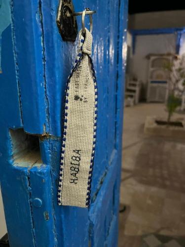 a tie is hanging on a blue door at Riad Houch Amine B&B in Midoun