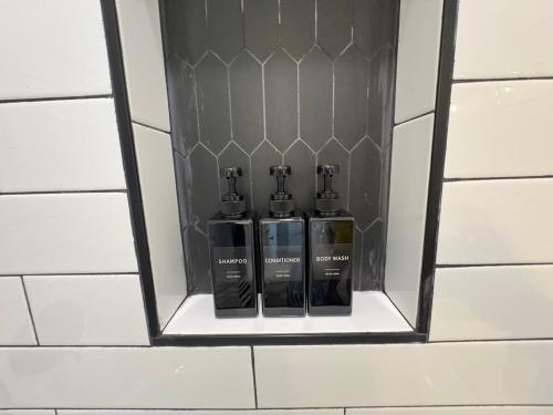 two bottles of essential oils in a niche in a bathroom wall at Modern 3BR, 2BAHome Near Georgetown Square Sleeps 6 in Georgetown