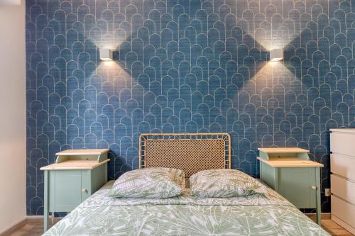 サン・モール・デ・フォッセにあるSaint-Maur Appartement Calme et Confortable, RER A, Bords de Marneのベッドルーム1室(ベッド1台、ナイトスタンド2台、テーブル2台付)