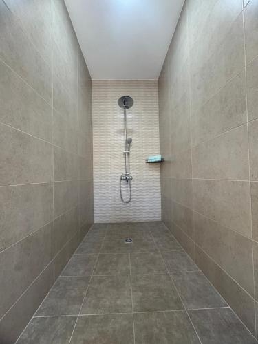 a bathroom with a shower with a tile wall at Hostal Las rejas in Archidona