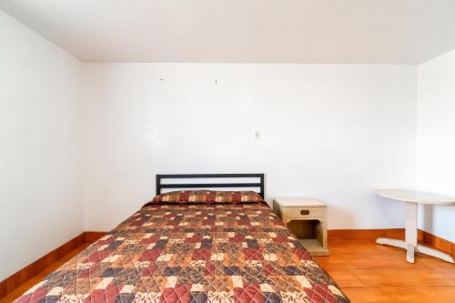 a bedroom with a bed and a table at Hotel O Colonial Inn Brownsville Tx in Brownsville