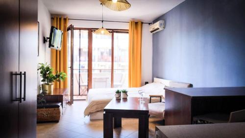 Un dormitorio con una cama y una mesa en una habitación. en Studio Comfort Blue, en Primorsko