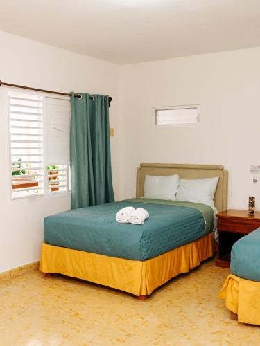 a bedroom with a bed with two towels on it at Casa Chetumal Hotel in Chetumal