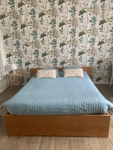 Studio 20 m2-Proche gare في لا روش سور يون: سرير مع لحاف أزرق في غرفة النوم