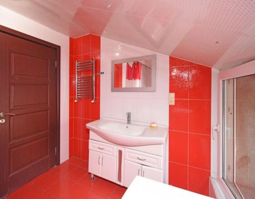 a bathroom with a sink and a red wall at Lux Villa Yerevan in Yerevan