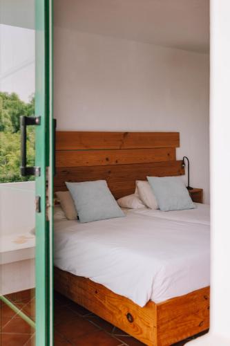a bedroom with a bed with a wooden headboard at Surfescape Fuerteventura in Lajares