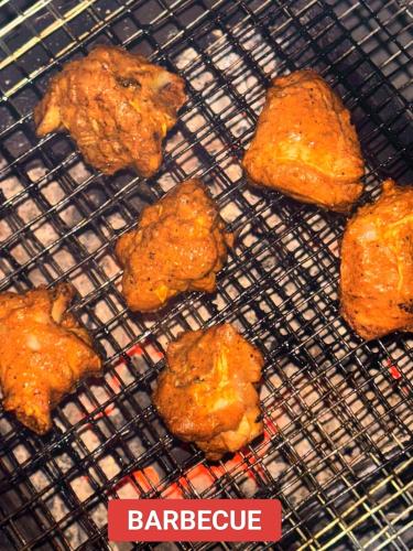 a bunch of food cooking on a grill at Hotel Falcon View in Darjeeling