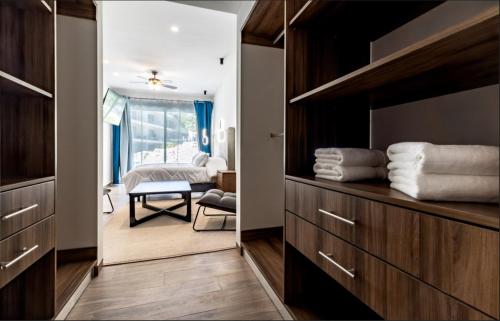 ein Zimmer mit einem Schlafzimmer mit einem Bett und einem Spiegel in der Unterkunft Departamento en zona exclusiva a minutos de la playa y de la 5ta Av in Playa del Carmen