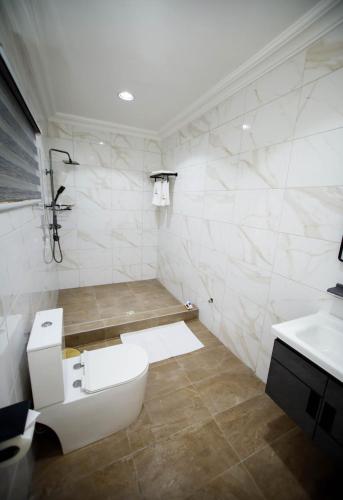 a bathroom with a toilet and a sink at Luxury 3BR Villa with smart Lock , Fast Wifi, Sure Parking in Oyarifa, Accra in Accra