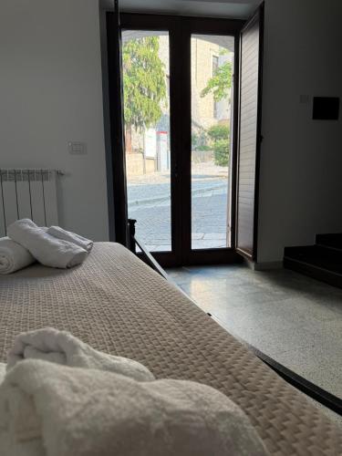 a bedroom with a bed and a large window at Casa Vacanza IsaCla al Castello in Montemiletto
