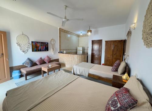 a hotel room with two beds and a couch at Lighthouse Residence in Dahab