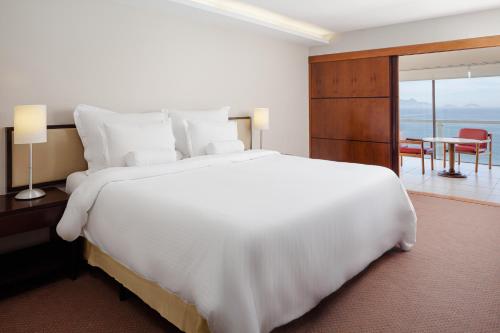 a bedroom with a large white bed and a table at Rio Othon Palace in Rio de Janeiro
