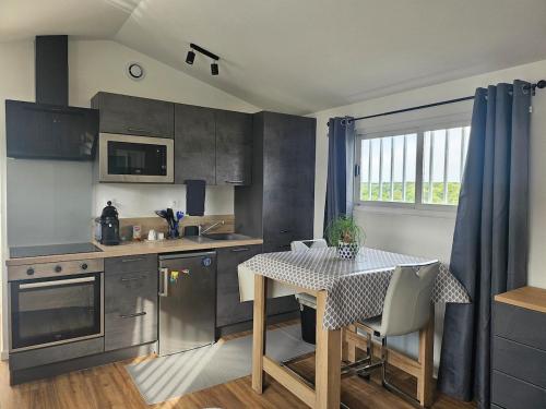 a kitchen with a table and a dining room at logement cocooning in La Celle-sous-Gouzon