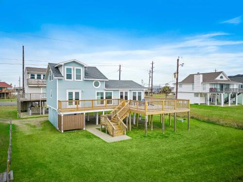a large house with a deck and a yard at Our Infinity Pool in Galveston