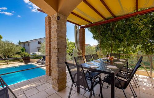 a patio with a table and chairs next to a pool at Holiday apartment Boko in Pinezici