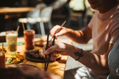 a group of people sitting at a table eating food with chopsticks at Surfescape Fuerteventura in Lajares