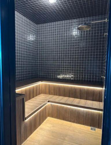 a sauna with a wooden floor and black tiles at Flat 602 - Mn Concept in Marília