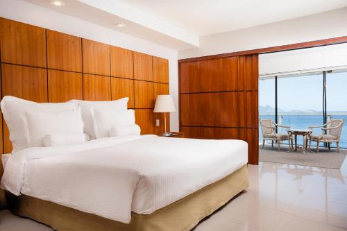 a bedroom with a large bed and a table at Rio Othon Palace in Rio de Janeiro