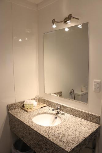 a bathroom with a sink and a large mirror at Airport Gateway Hotel in Auckland