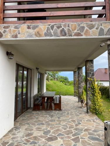a patio with a wooden table and a bench at Popasul din Pietrar in Preluca Veche