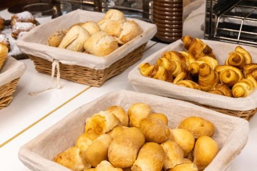 a bunch of baskets of bread on a table at The ICONS Lisbon Hotel in Lisbon