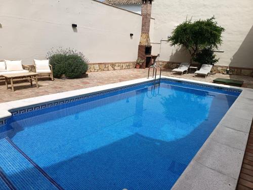 a large swimming pool with blue water in a yard at REFUGiO MAGiCO in Herencia