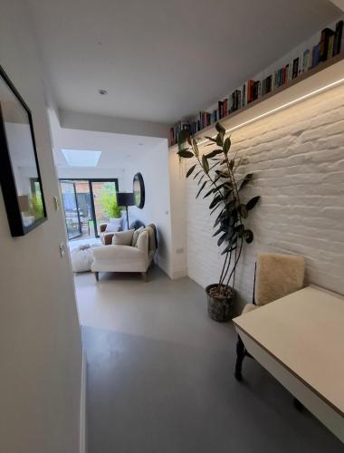 a living room with a couch and a table at Elegant Garden Flat - Raynes Park in Raynes Park