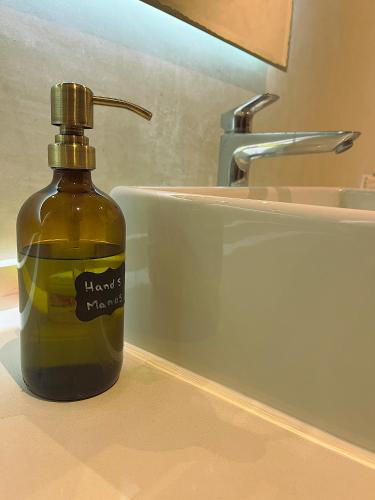 a bottle of liquid soap sitting on a bathroom sink at Casita Oleaje Luxury Cultural Sanctuary Spa in Tulum