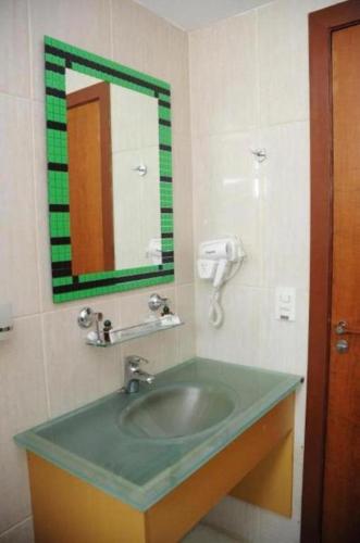 a bathroom with a green sink and a mirror at Hotel Family São Paulo - No Shopping FAMILY - No Brás in Sao Paulo