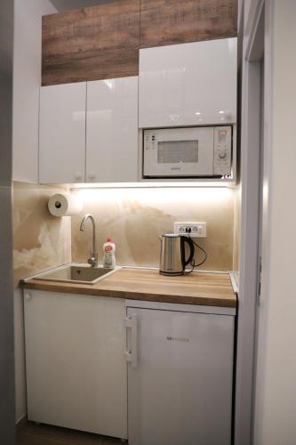a small kitchen with a sink and a microwave at Point Apartman in Belgrade