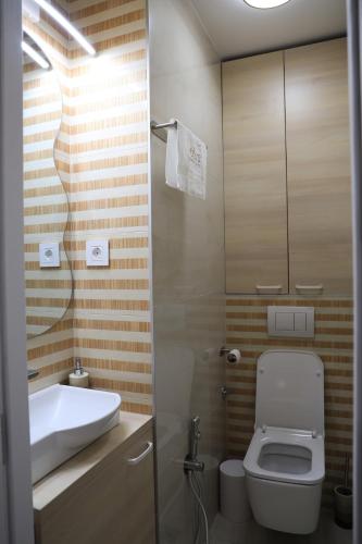 a bathroom with a toilet and a sink at Point Apartman in Belgrade