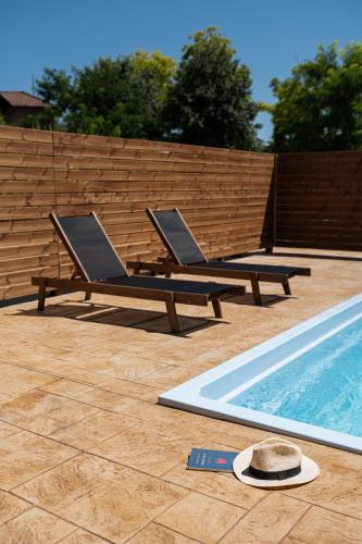 two lounge chairs sitting next to a swimming pool at Kanva Suites in Korinós