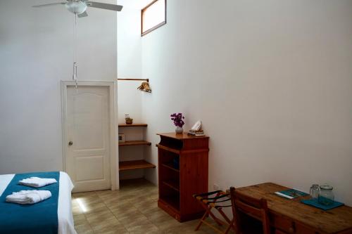 a bedroom with a bed and a desk and a table at Hotel Albemarle Galapagos Beachfront in Puerto Villamil