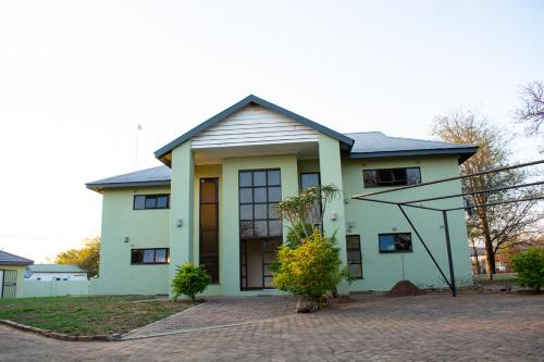 a large white house with at Staybridge Chobe Safari Resort in Kasane