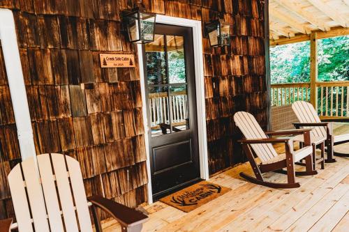 a wooden cabin with chairs and a table and a door at Creekside Cabin in Pigeon Forge